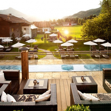 Hotelschwimmbad mit Holzterrasse und Blick auf den Außenool