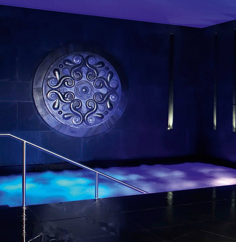 Hotelschwimmbad Innenpool blau beleuchtet mit Wandschmuck