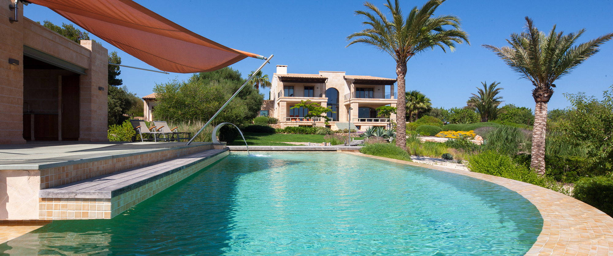 Majorcan outdoor pool in back yard with terrace and palm trees