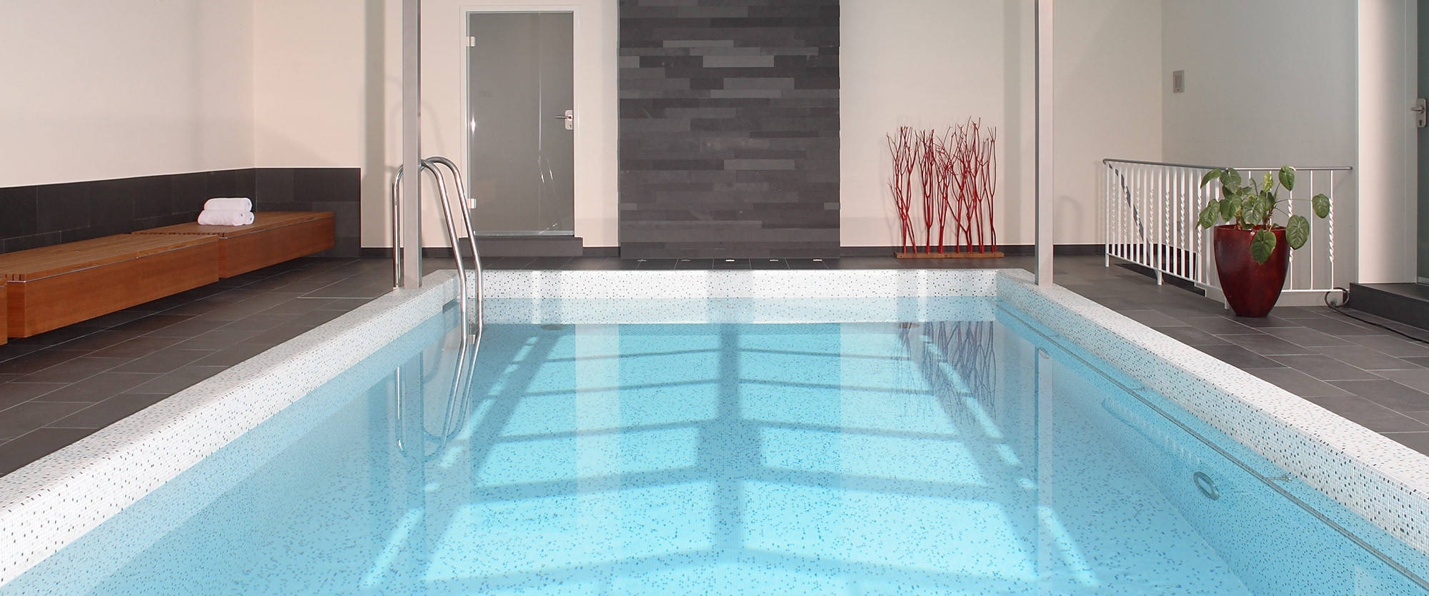 Indoor pool with view of a slate wall