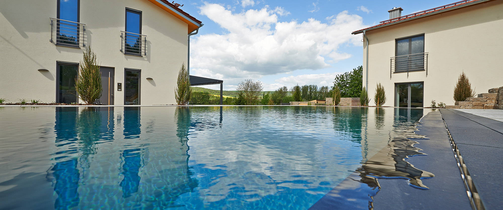 Outdoor pool with residential houses and view of the landscape