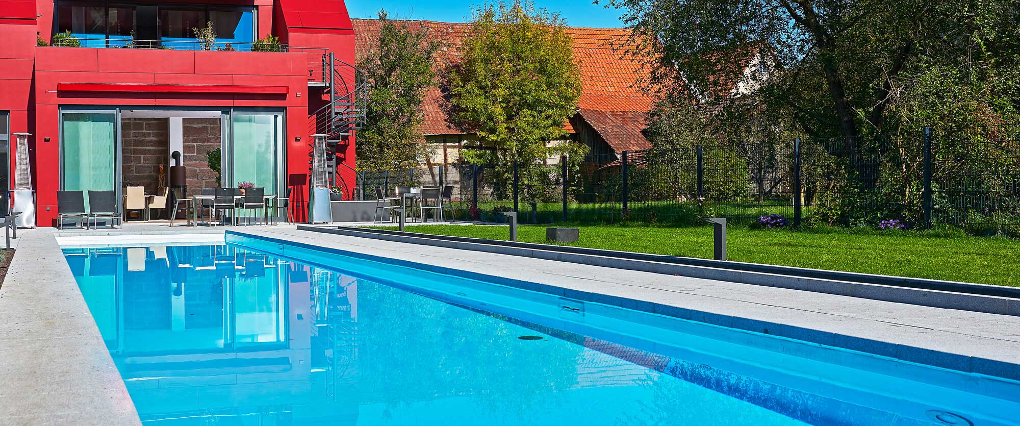 Outdoor pool with pool edge and back yard