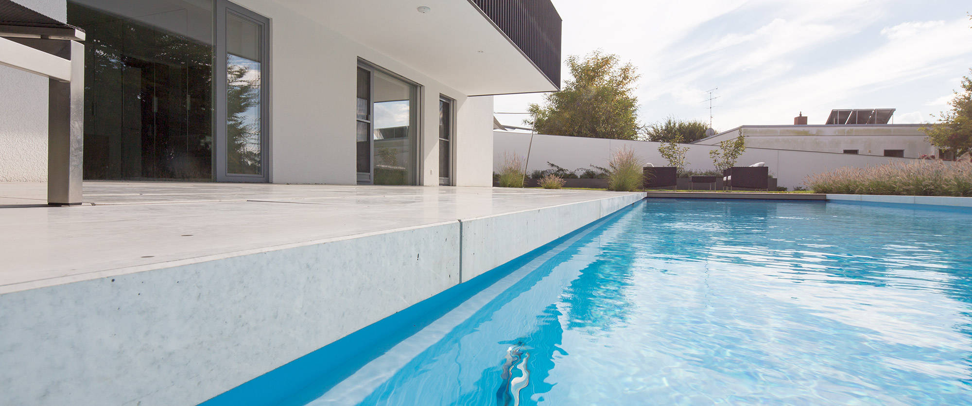 Outdoor pool with pool edge made of bright stone