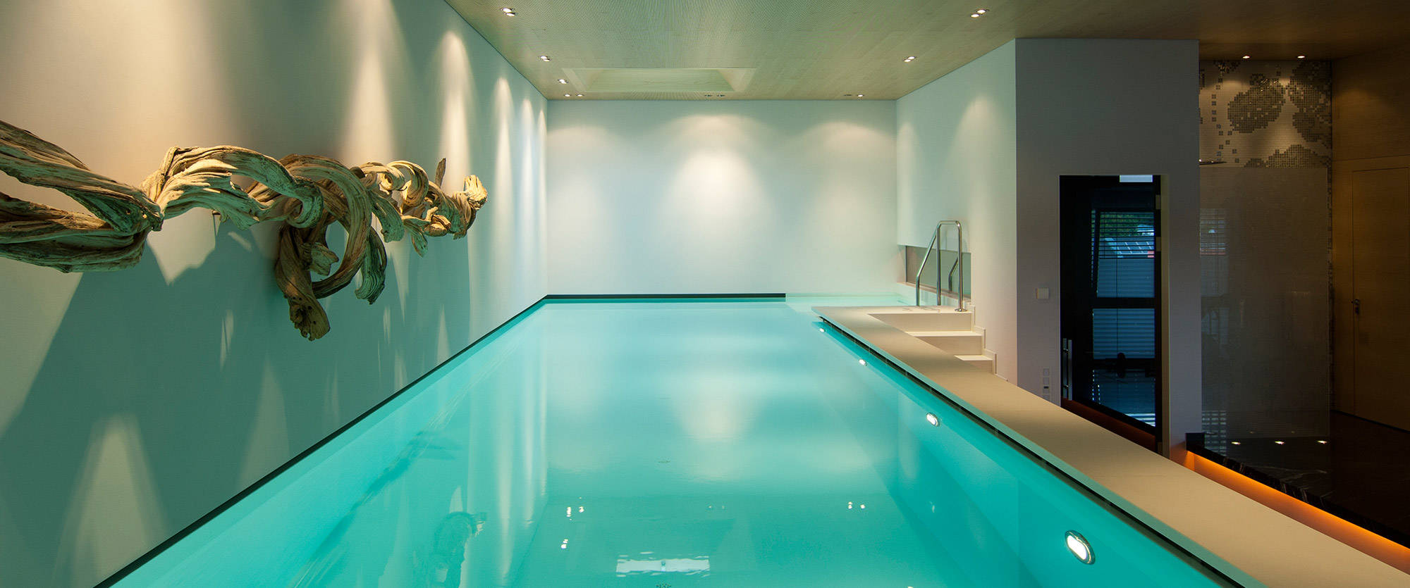 Indoor pool illuminated with wooden artwork